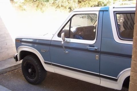 1985 Ford Bronco - The side profile of a two-tone Ford Bronco shows its classic SUV body style.