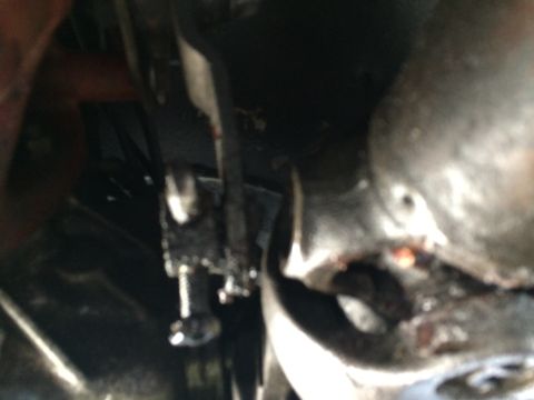 1997 Dodge 3500 - Close-up of a greasy t-case shifter linkage with visible bolts and metal parts.