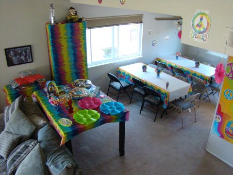 1989 Ford Bronco - A room decorated with tie-dye and peace signs, set up for a party with tables and chairs.