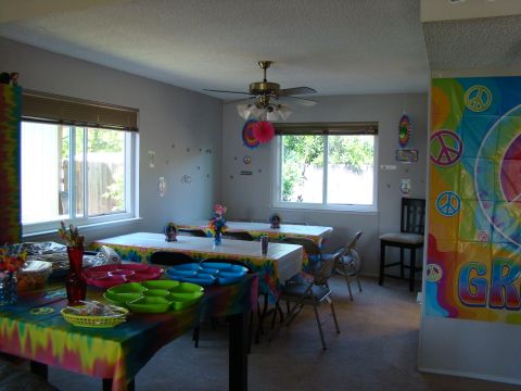 1989 Ford Bronco - A room is decorated for a party with tie-dye patterns and peace signs, tables set for guests.