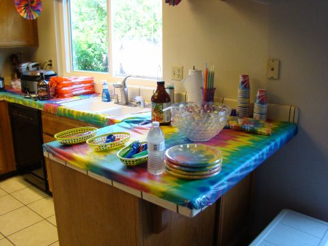 1989 Ford Bronco - A kitchen counter is set up for a party with tie-dye decorations and serving items.