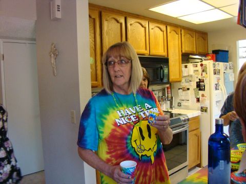 1989 Ford Bronco - A woman in a colorful tie-dye shirt stands in a kitchen, holding a cup and a small trinket.