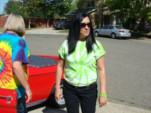 1989 Ford Bronco - A red convertible is parked on a residential street with two people standing nearby.