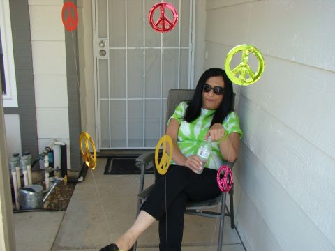 1989 Ford Bronco - A woman relaxes on a porch decorated with peace signs, holding a bottle of water.
