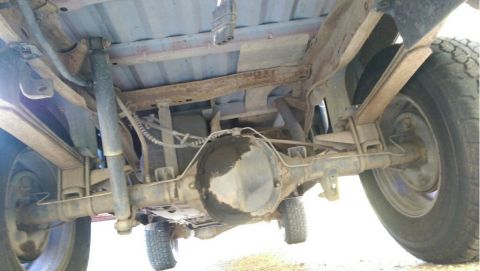 1991 Ford F-250 - The underside of a pickup truck, showing the rear axle, leaf springs, and shock absorbers.