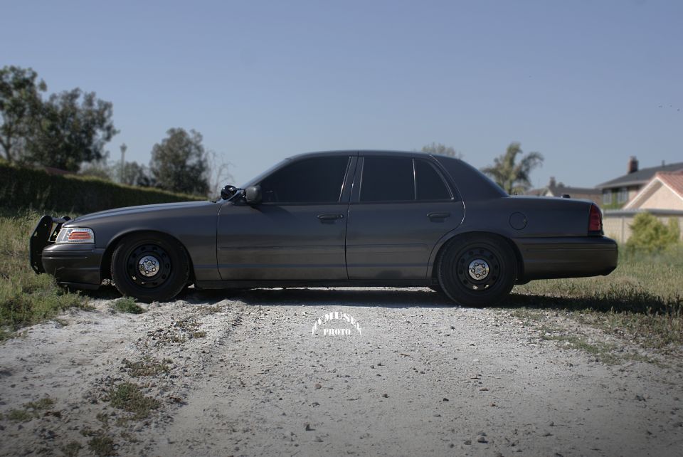 Dark gray 2005 Ford Crown Victoria, side view, with push bumper and tinted windows