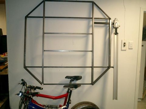 1990 Ford Bronco - A custom metal rack is mounted on a wall, with a bicycle positioned beneath it.