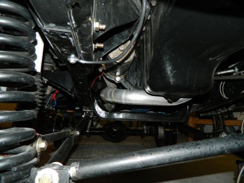 1979 Ford Bronco - Close-up of vehicle undercarriage, showing suspension components and exhaust system.