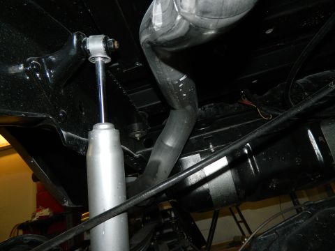 1979 Ford Bronco - Close-up view of the undercarriage, focusing on the shock absorber and exhaust system components.