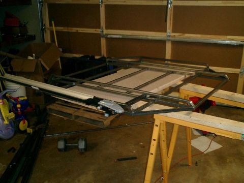 1990 Ford Bronco - Metal rack assembly on sawhorses with Thule rack components in a garage.