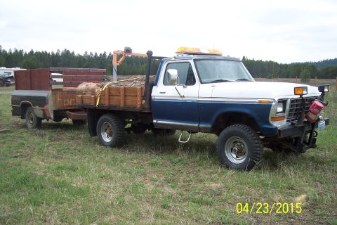 1973 Ford F-250 - This 1973 Ford F-250 flatbed truck is equipped for logging and tows a trailer.