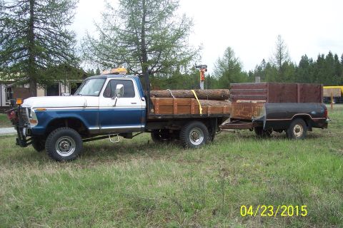 1973 Ford F-250 - This 1973 Ford F-250 flatbed truck is equipped to haul logs and tows a trailer.