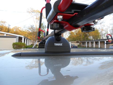 2000 Ford Ranger - A close-up view of a Thule roof rack system carrying kayak carriers.