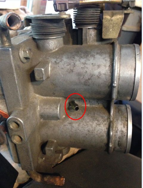 1993 Ford Bronco - Carburetor part with a vacuum nipple circled in red.