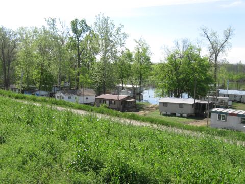 2006 Suzuki DR-Z400S - A collection of mobile homes are situated near a body of water surrounded by trees.