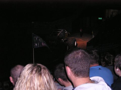1996 Ford Bronco - A monster truck is on display at an event, viewed from behind an audience.