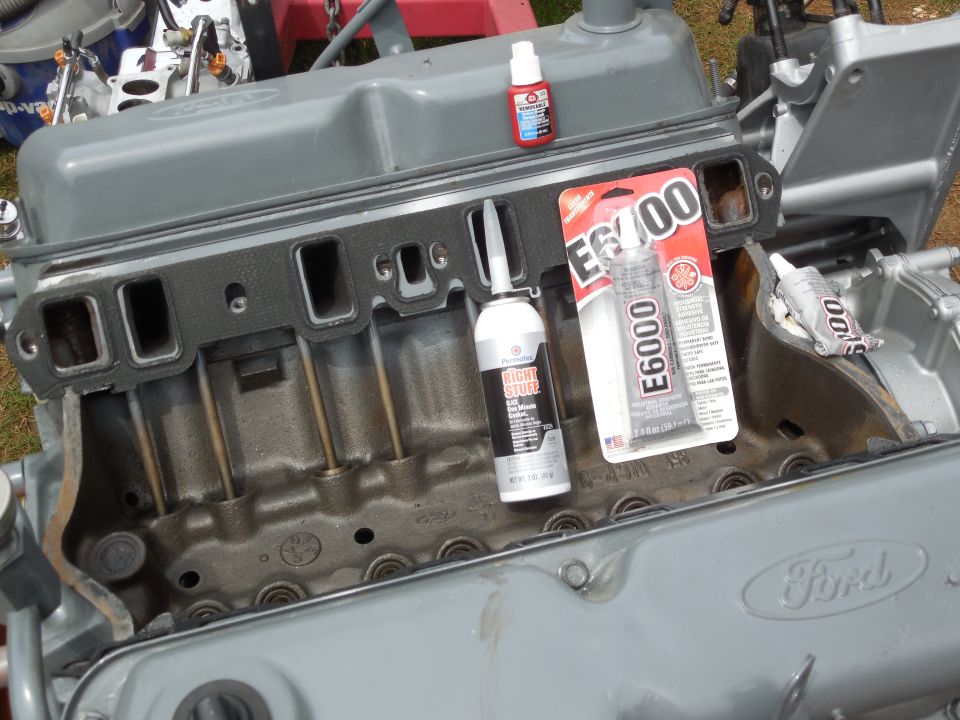 Gray Ford engine block with Permatex Right Stuff and E6000 adhesive tubes on top