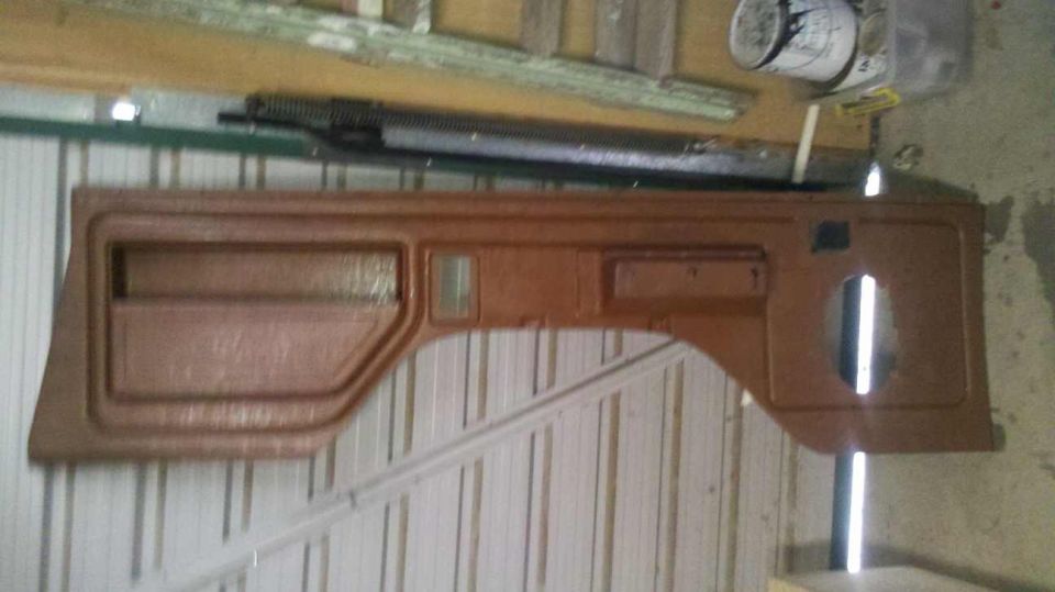 Brown door panel with speaker cutout and storage pocket