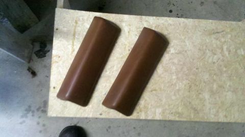 1982 Ford Bronco - Two brown door trim pieces are shown on a light-colored wooden surface.