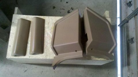 1982 Ford Bronco - Several tan interior door trim pieces are laid out on a wooden platform.