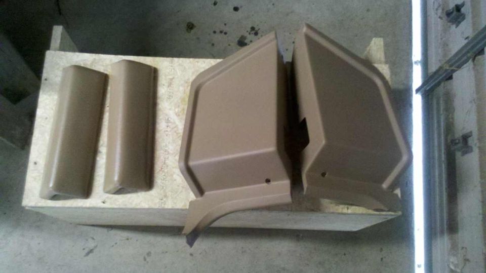 Tan door trim panels and two vertical trim pieces on a wooden surface