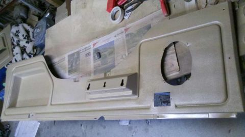 1982 Ford Bronco - A tan interior door panel with a large speaker cutout and a storage pocket is shown.