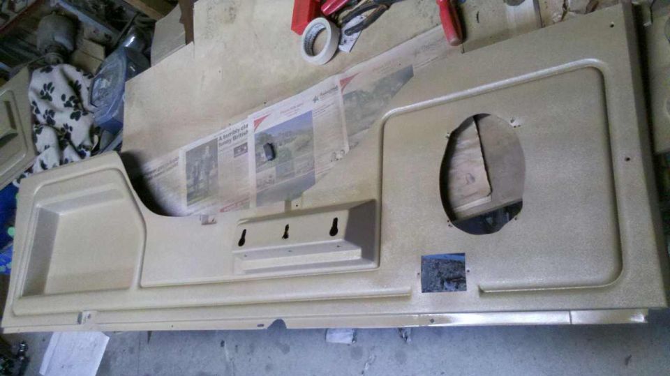 Tan interior door panel with speaker cutout and storage pocket
