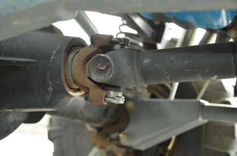 1979 Ford Bronco - Close-up view of a vehicle's driveshaft and U-joint, showing signs of rust.