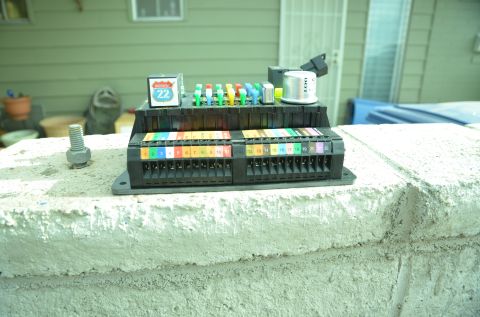 1979 Ford Bronco - An automotive fuse box with multiple rows of fuses and numbered terminals is displayed outdoors.