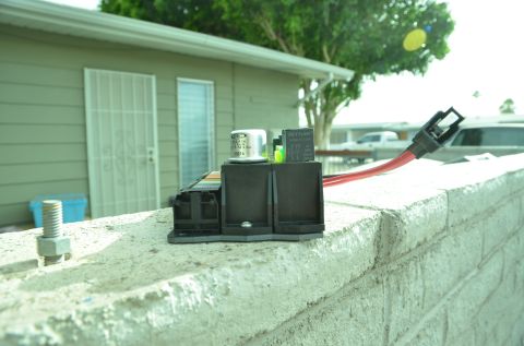 1979 Ford Bronco - Close-up of an automotive fuse box and wiring harness, placed on a wall outdoors.