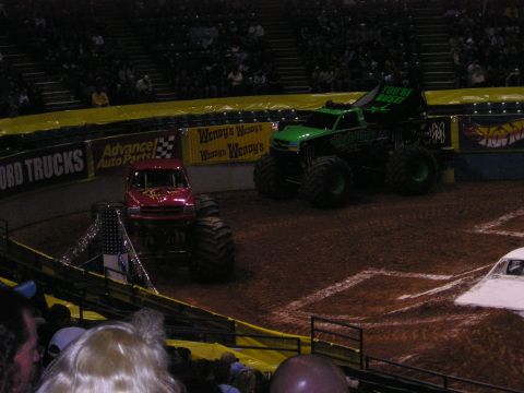 1996 Ford Bronco - Monster trucks compete in an arena, with banners for Wendy's and Advance Auto Parts visible.