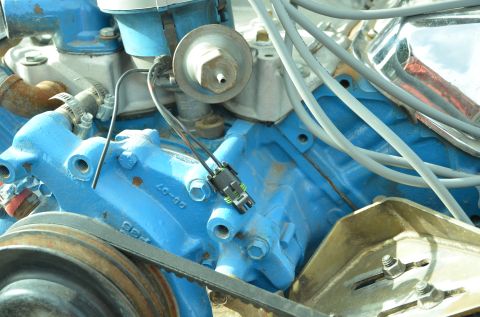 1979 Ford Bronco - Close-up view of engine components, including a blue painted block, belt, pulley, and wiring.