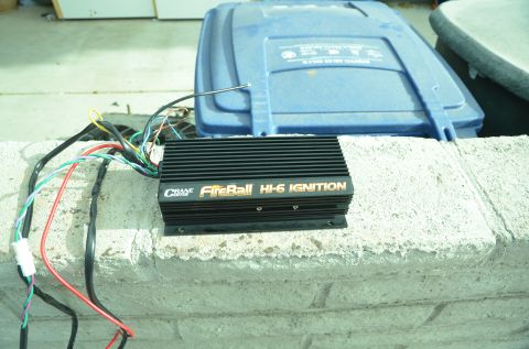 1979 Ford Bronco - A Crane FireBall HI-6 Ignition module with its wiring harness is shown resting on a concrete ledge.