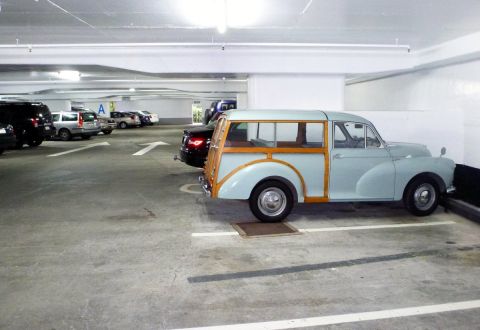 1969 MINI Cooper - A light blue woody station wagon is parked in a garage next to other vehicles.