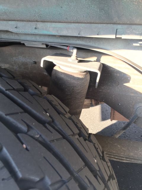 1996 Ford Bronco - This photo shows the rear suspension of a vehicle, including a tire and an air spring assembly.