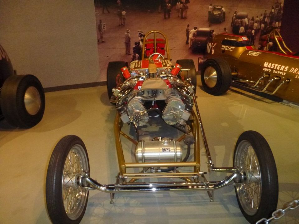 Dragster chassis with dual V8 engines, chrome suspension, and wire wheels