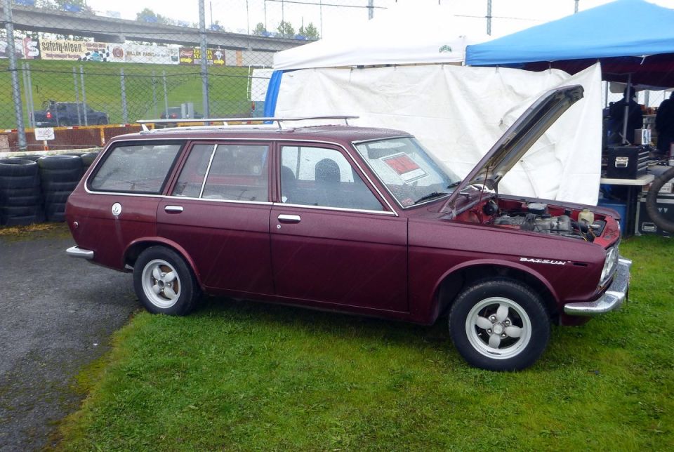 Maroon Datsun station wagon, hood open, side view