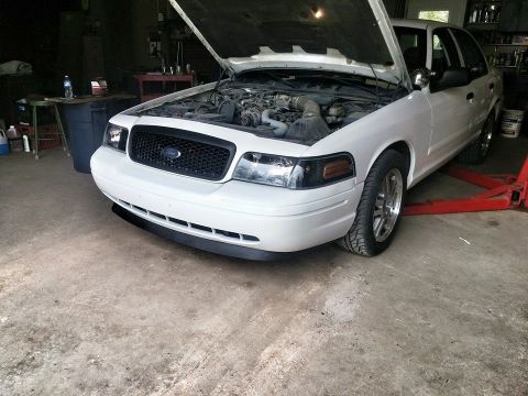 2000 Mercury Grand Marquis - Front 3/4 view of a white 2000 Mercury Grand Marquis with its hood open, revealing the engine bay.