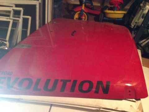 1979 Ford Bronco - A red car hood with "ROAD EVOLUTION" text is shown indoors, possibly in a garage.