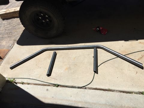 1995 Ford Bronco - A custom roll cage section lies on the ground next to a vehicle's tire.