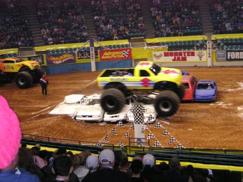 1996 Ford Bronco - A monster truck event with multiple vehicles on a dirt track in an arena.
