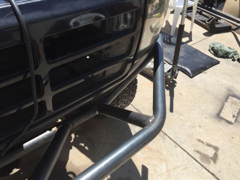 1995 Ford Bronco - Close-up of a black Ford Bronco's front end, showing the grille and a custom tubular bumper, with a Supermotors.net logo visible.