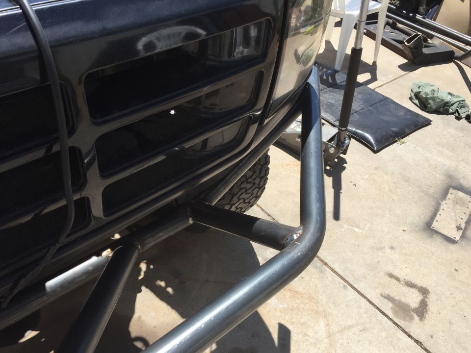 Black Ford Bronco grille with aftermarket tubular bumper. Tire visible. Supermotors.net logo