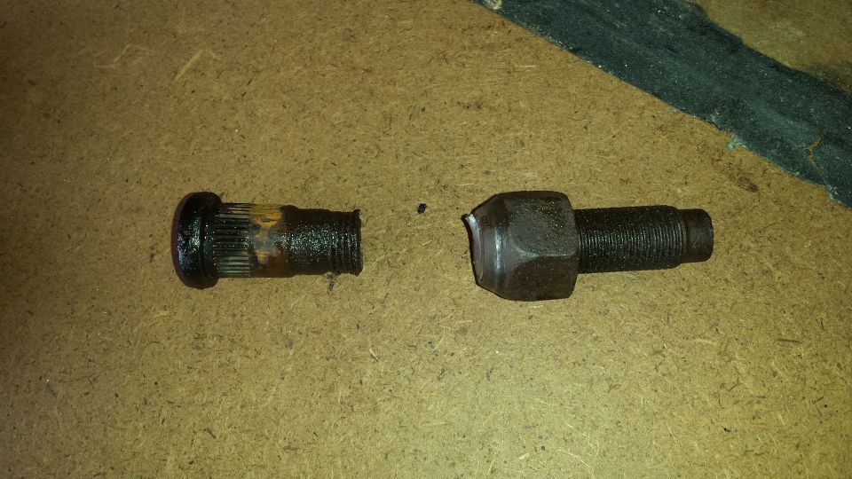 Broken wheel stud and lug nut on a workbench
