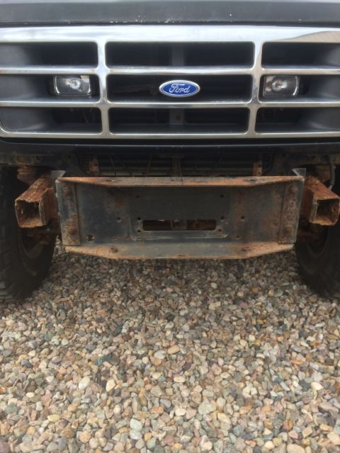1993 Ford Bronco - Front view of a 1993 Ford Bronco, highlighting its rusty bumper and tow hitch receiver.