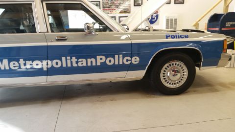 1991 Ford LTD Crown Victoria - This police car has 'Metropolitan Police' written on its side and the hood is open.