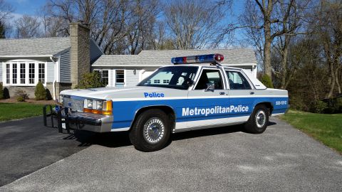 1991 Ford LTD Crown Victoria - Metropolitan Police car, likely a 1991 Ford Crown Victoria LTD, parked in a driveway.