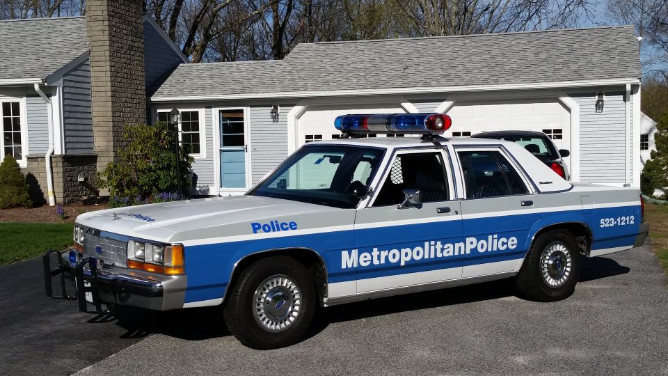 1991 Ford Crown Victoria LTD police car, white and blue, parked in driveway