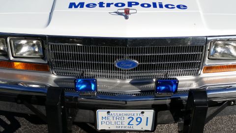 1991 Ford LTD Crown Victoria - Front view of a white police car, a Ford grille, blue emergency lights, and a Massachusetts license plate.