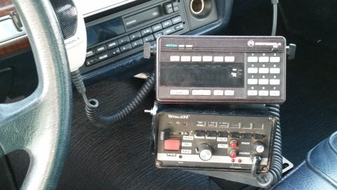 1991 Ford LTD Crown Victoria - The interior of a vehicle shows a Motorola radio and a Whelen control unit, suggesting police or emergency service use.